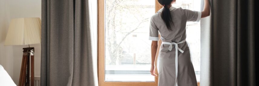housekeeper cleaning windows